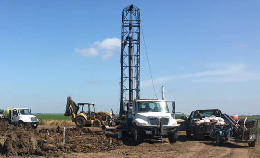 Mid-Valley Drilling Rig drilling a for a well in a field. Mid-Valley Drilling Rig drilling a for a well in a field.