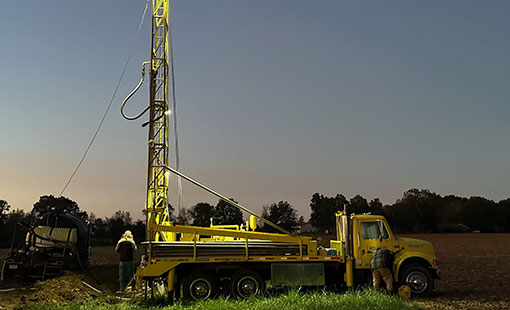 Mid-Valley Drilling Rig drilling a for a well in a field at night. Mid-Valley Drilling Rig drilling a for a well in a field at night.